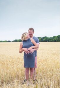 husband and wife embracing in a field in norfolk