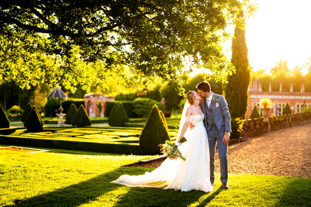 bride and groom at golden hour in oxnead hall gardens